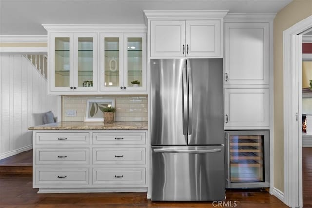 interior space featuring baseboards, freestanding refrigerator, dark wood-style flooring, and wine cooler