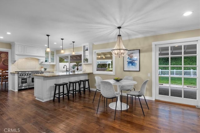 dining area featuring recessed lighting, ornamental molding, dark wood finished floors, and baseboards