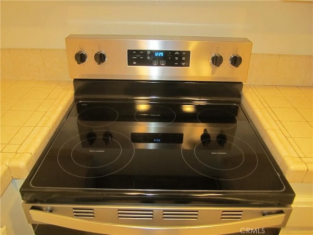 2321 S Magnolia Ave Unit 6A, Ontario, CA 91762 - room details with stainless steel electric stove, tasteful backsplash, and tile countertops