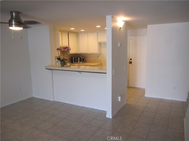 2321 S Magnolia Ave Unit 6A, Ontario, CA 91762 - kitchen featuring a peninsula, baseboards, recessed lighting, light countertops, and white cabinetry