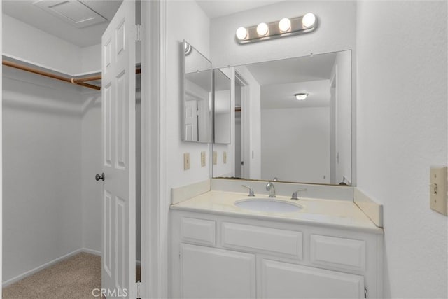 bathroom featuring a spacious closet and vanity