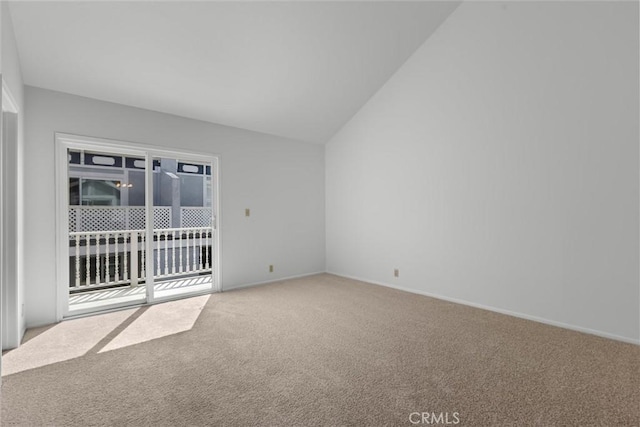 spare room featuring vaulted ceiling, baseboards, and carpet flooring