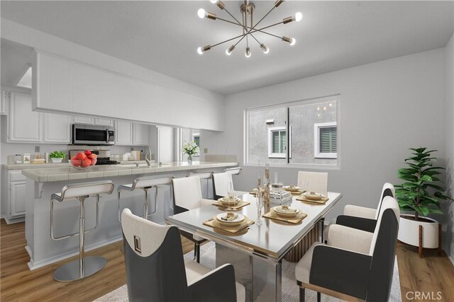 dining space featuring light wood-type flooring and a notable chandelier