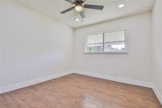 spare room with a ceiling fan, a textured ceiling, wood finished floors, baseboards, and recessed lighting