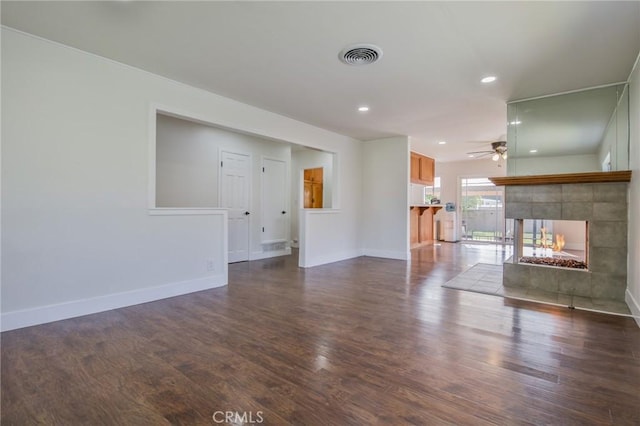 unfurnished living room with dark wood-style flooring, visible vents, a fireplace, baseboards, and recessed lighting