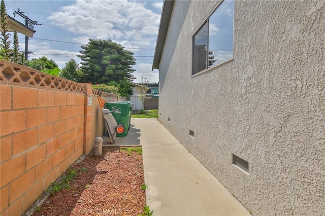 view of home's exterior with crawl space, fence, and stucco siding