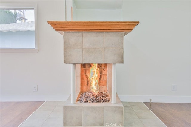 details featuring a tiled fireplace and baseboards
