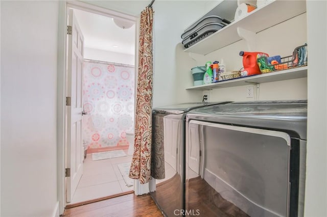 laundry area featuring laundry area, washing machine and dryer, and wood finished floors