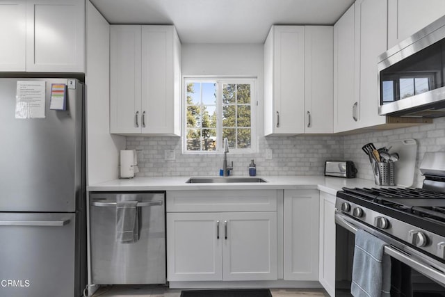 1104 E Big Bear Blvd, Big Bear, CA 92314 - kitchen featuring white cabinets, appliances with stainless steel finishes, a sink, light countertops, and tasteful backsplash