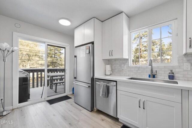 1104 E Big Bear Blvd, Big Bear, CA 92314 - kitchen with light countertops, white cabinets, a sink, appliances with stainless steel finishes, and backsplash