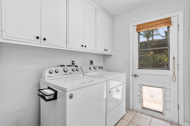 laundry area featuring cabinet space, light tile patterned floors, and washing machine and clothes dryer