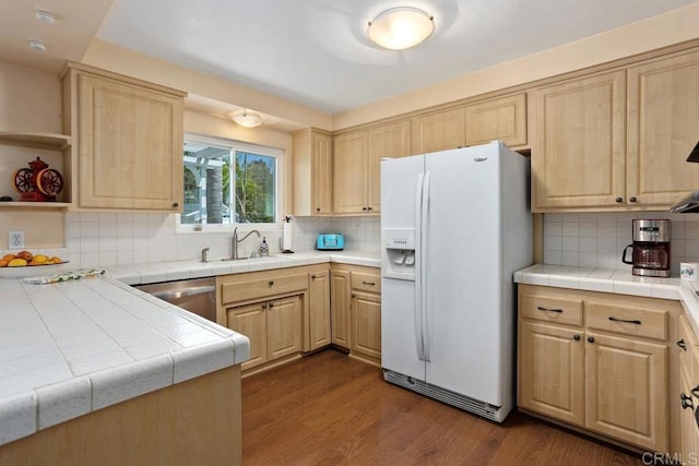 kitchen featuring light brown cabinetry, backsplash, dark wood finished floors, and white fridge with ice dispenser