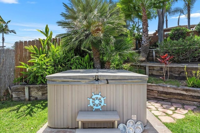 view of outdoor structure featuring a hot tub and fence