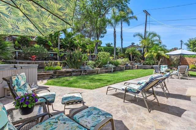 view of patio featuring fence and a jacuzzi