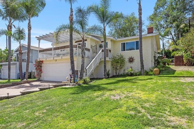 view of front facade featuring a chimney, stucco siding, a front yard, and concrete driveway