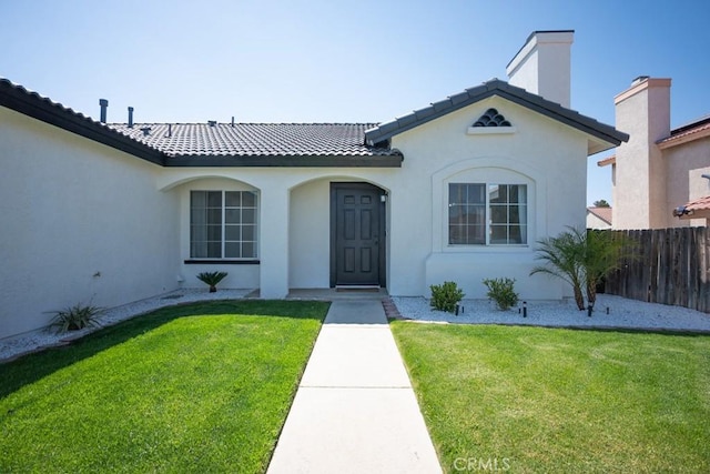 36711 Silverspur Ln, Palmdale, CA 93550 - mediterranean / spanish house featuring stucco siding, a front lawn, fence, and a chimney
