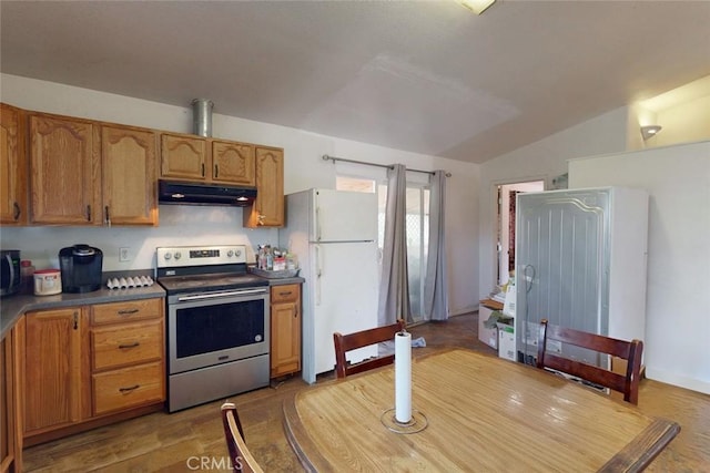 kitchen featuring dark countertops, brown cabinets, freestanding refrigerator, electric stove, and under cabinet range hood