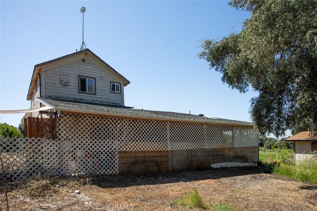 rear view of house with a shingled roof