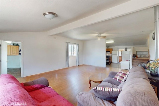 living room with a ceiling fan, beamed ceiling, and wood finished floors