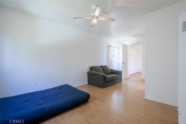 bedroom with baseboards, a ceiling fan, and light wood-style flooring