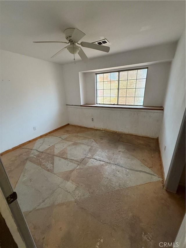 spare room featuring baseboards, a ceiling fan, and visible vents