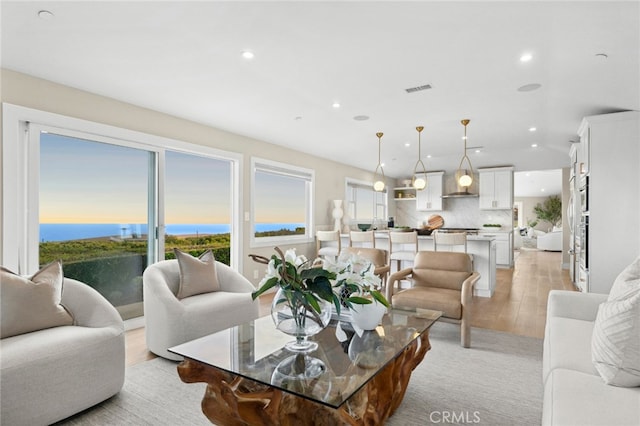 living room featuring recessed lighting, light wood-type flooring, and a wealth of natural light
