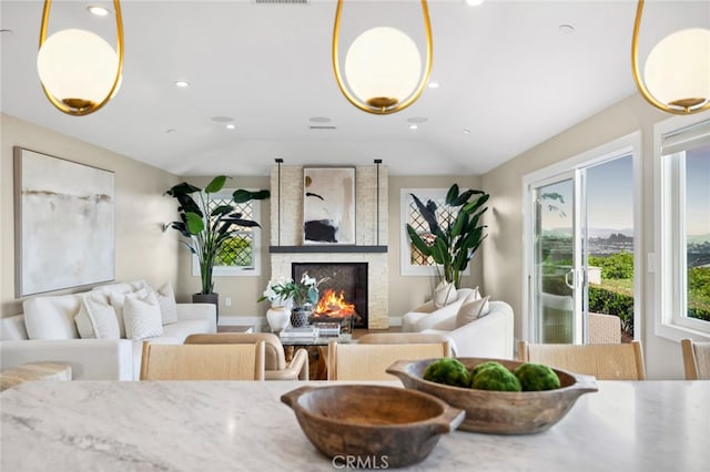 living room with recessed lighting, vaulted ceiling, a wealth of natural light, and a fireplace