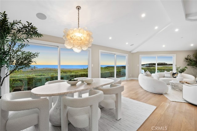 dining room with recessed lighting, an inviting chandelier, vaulted ceiling, and light wood-type flooring