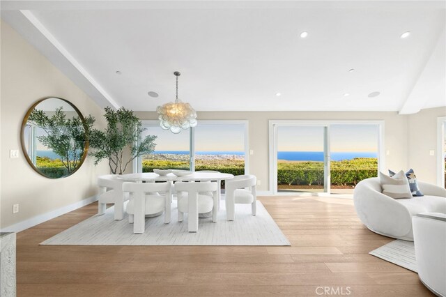 dining room featuring baseboards, recessed lighting, wood finished floors, and a notable chandelier