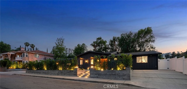 single story home with a gate, board and batten siding, and fence