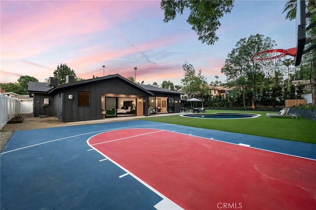 view of sport court featuring a fenced in pool, fence, a yard, and basketball hoop