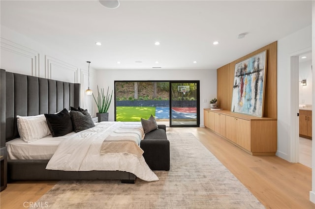 bedroom with recessed lighting, access to outside, and light wood finished floors