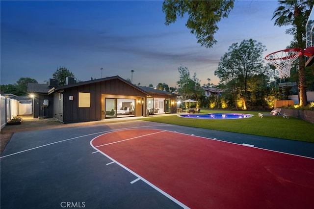 view of basketball court featuring an outdoor pool, fence, a yard, and basketball court