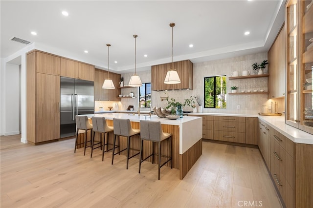 kitchen featuring visible vents, open shelves, built in refrigerator, and modern cabinets
