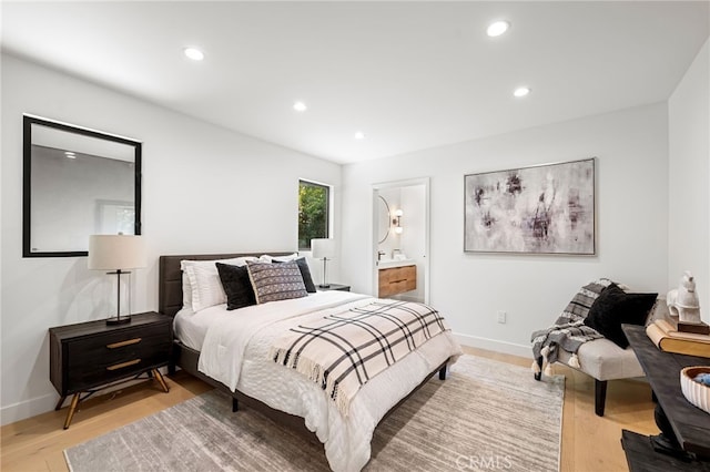 bedroom with light wood-style floors, recessed lighting, baseboards, and ensuite bath