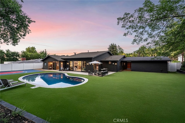 view of swimming pool with a lawn, a fenced in pool, a patio, and a fenced backyard