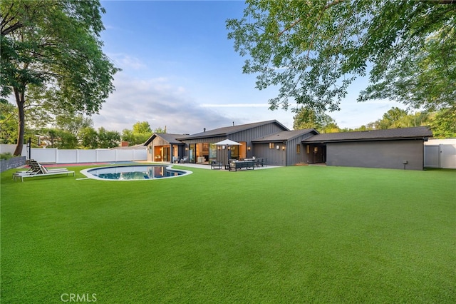 view of yard with a fenced backyard, a fenced in pool, and a patio area