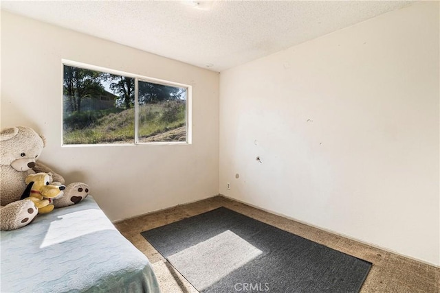 unfurnished bedroom featuring a textured ceiling and carpet