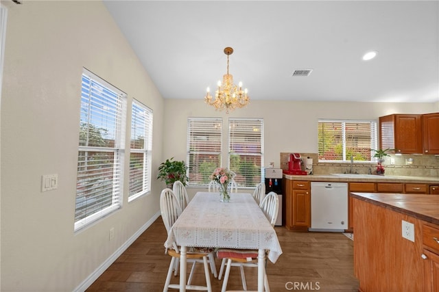 kitchen featuring visible vents, an inviting chandelier, wood finished floors, a sink, and dishwasher