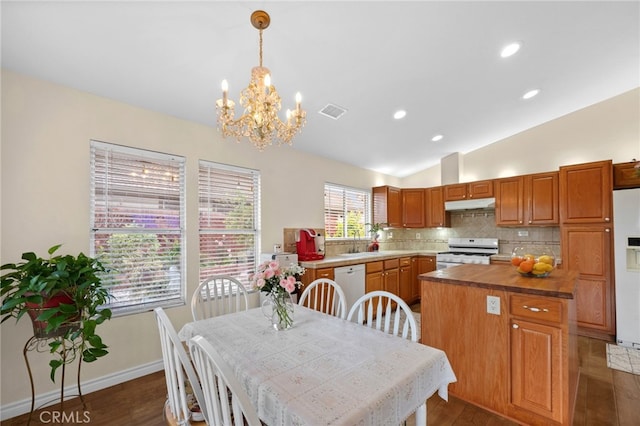 dining area featuring vaulted ceiling, a notable chandelier, dark wood-style floors, and visible vents