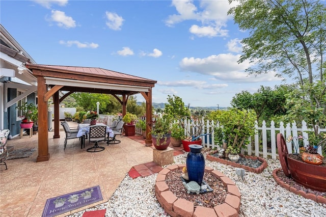 view of patio with a fenced backyard, outdoor dining space, and a gazebo