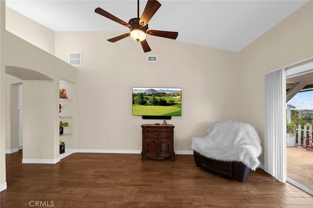 living area featuring visible vents, a ceiling fan, and a towering ceiling