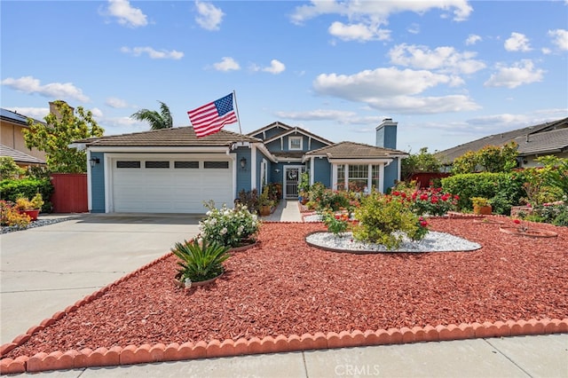 view of front of house featuring concrete driveway, an attached garage, and fence