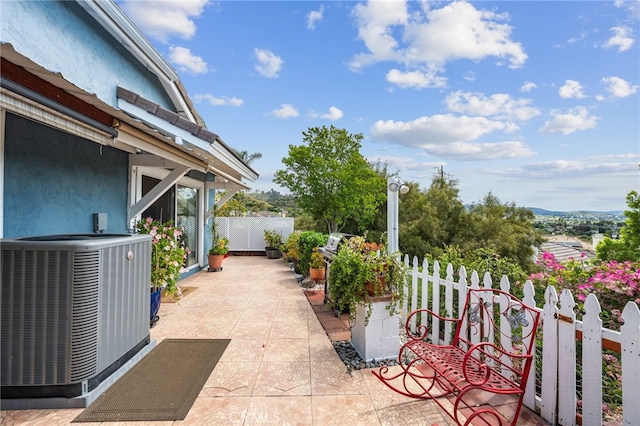 view of patio with central air condition unit and fence