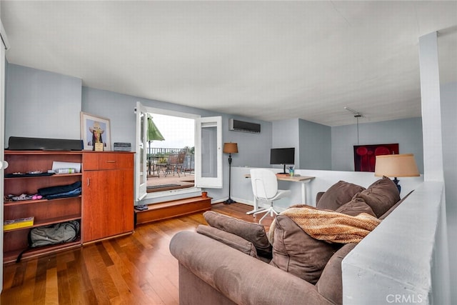 living area featuring a wall unit AC and wood finished floors