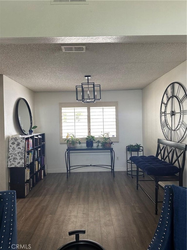 dining space featuring visible vents, baseboards, a textured ceiling, and wood finished floors