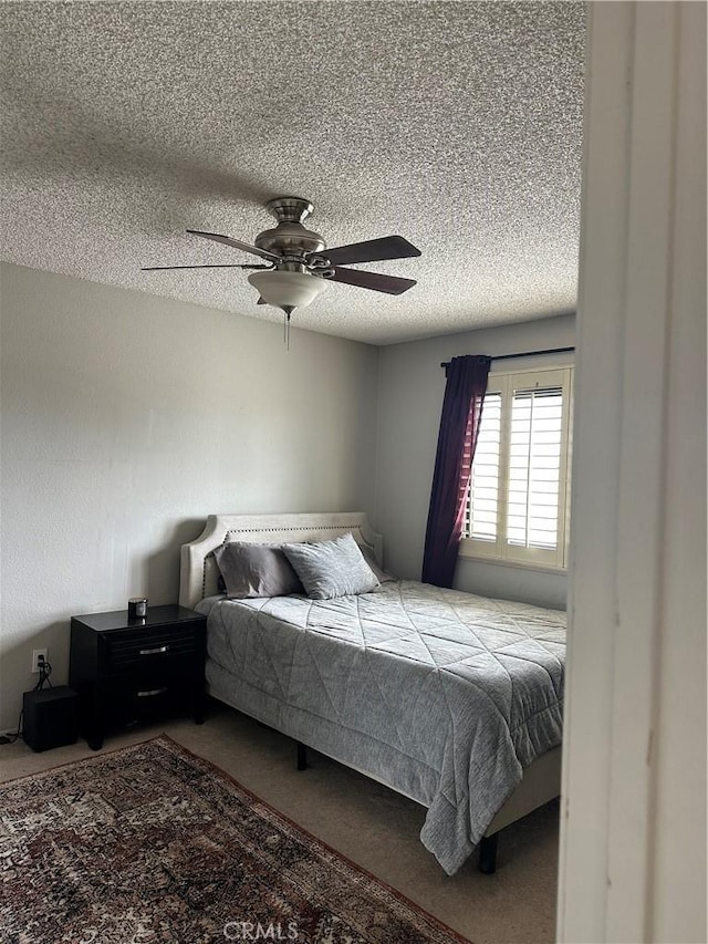 bedroom featuring a textured ceiling, ceiling fan, and carpet
