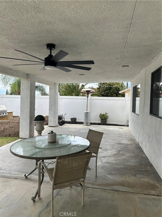 view of patio / terrace with ceiling fan, fence, and outdoor dining space