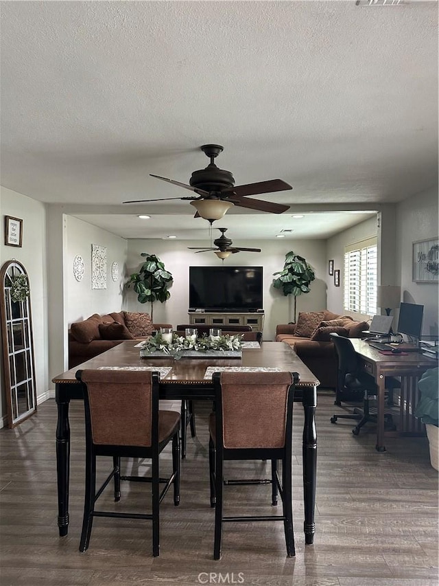 dining room featuring a ceiling fan, a textured ceiling, and dark wood finished floors