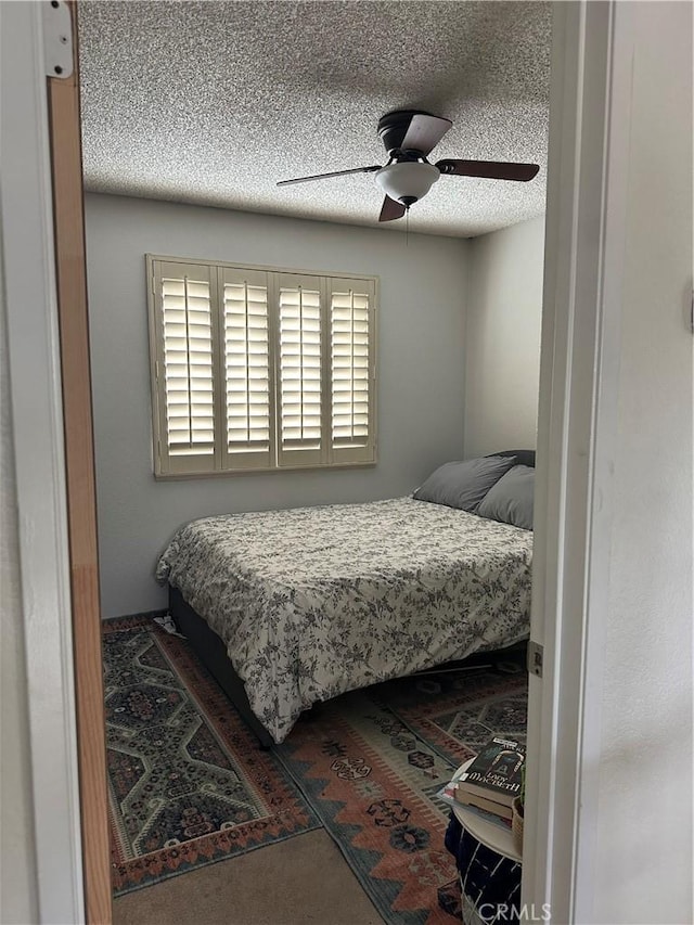 bedroom featuring ceiling fan and a textured ceiling